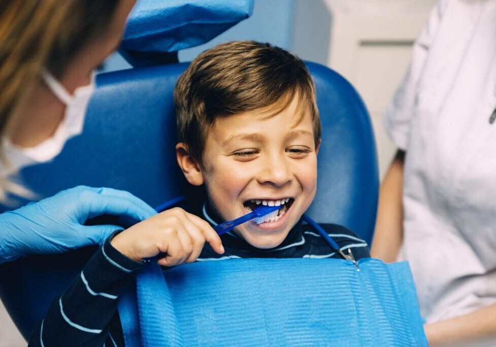 Doctor dentist teaching a child to brush teeth. Dentist concept.