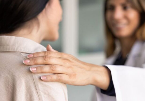 Doctor with their hand on a patient's shoulder